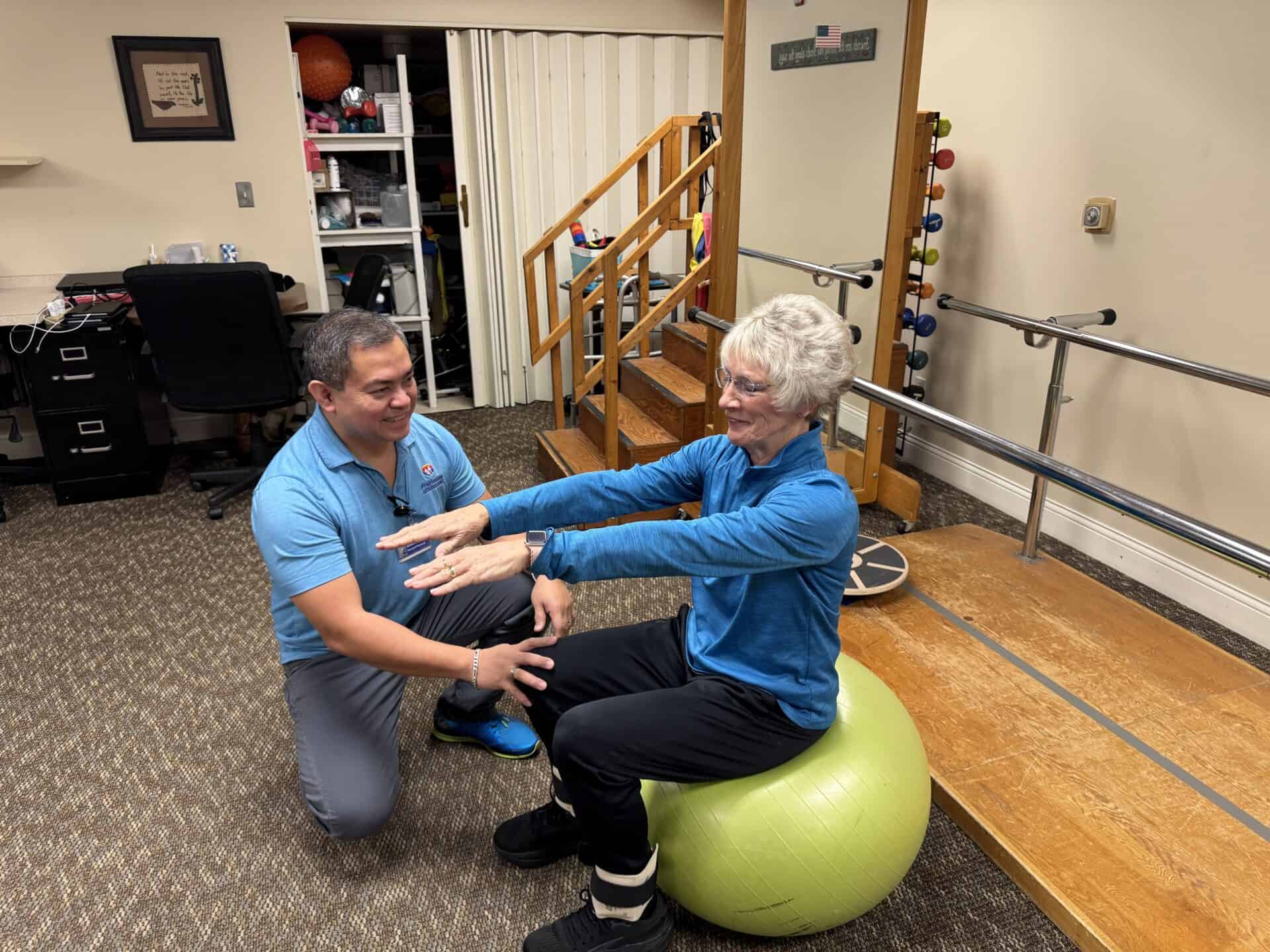 Physical therapist assisting woman with balance exercise