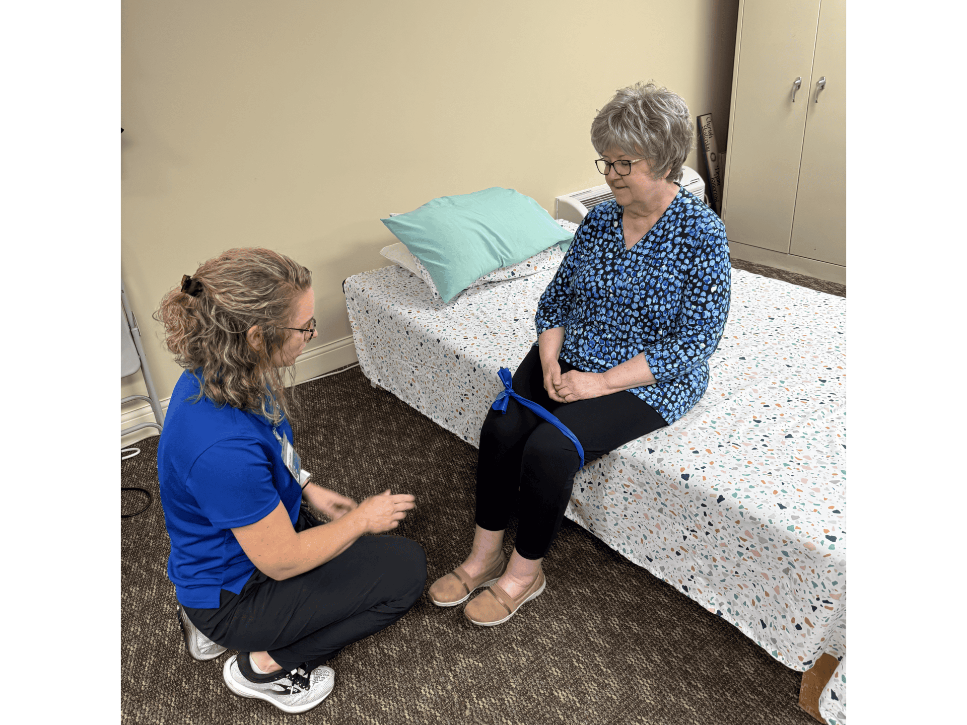 Therapist assisting woman with seated leg exercise