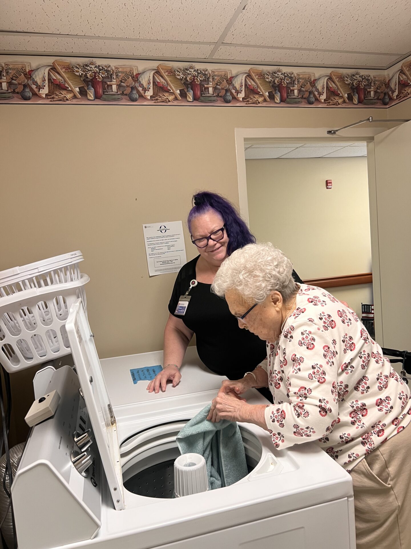 Caregiver assists elderly woman loading=